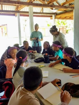 Kathy helps the students fill in sketching details and colors, and scientific information on what they saw in the forest.
